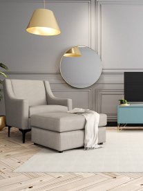A grey occasional chair and ottoman in a modern lounge.