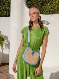 A lady wearing a green jumpsuit with a Cape Cobra sling bag