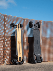 Two Evolve skateboards resting against a wall